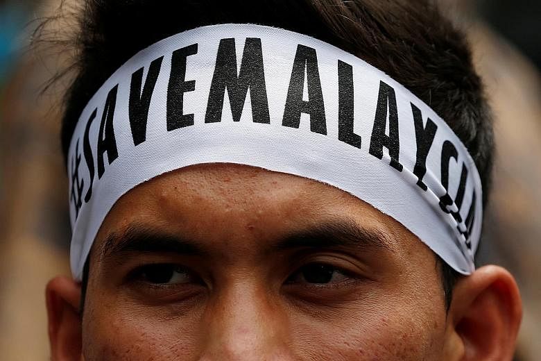 A student activist sports his message on a headband before the march calling for the arrest of "Malaysian Official 1" in Kuala Lumpur yesterday.