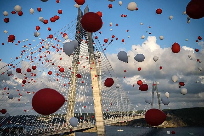 Balloons flying past the Yavuz Sultan Selim Bridge at its opening on Friday. The 1.4km bridge creates a new link across the Bosphorus Strait, which divides Asia and Europe. President Erdogan hopes to use such large-scale projects to drive Turkey's ec