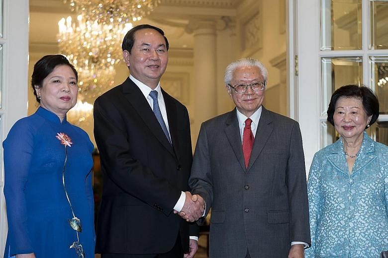 Vietnam's President Quang and his wife, Madam Nguyen Thi Hien with President Tan and Mrs Mary Tan at the Istana yesterday. PM Lee Hsien Loong and Vietnamese President Tran Dai Quang meeting at the Istana yesterday. President Tony Tan Keng Yam raising
