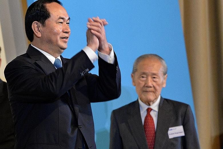 Vietnamese President Tran Dai Quang (left) greeting the audience at the 38th Singapore Lecture yesterday, where he delivered his talk before 550 people, including political and business leaders. On the right is Professor Wang Gungwu, chairman of the 
