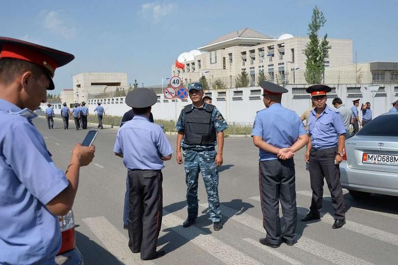 Kyrgyz police officers outside the Chinese embassy in Bishkek yesterday after a suicide bomber crashed his van through a gate of the compound. Kyrgyz law enforcement sources said the strength of the blast was equivalent to up to 10kg of TNT. 