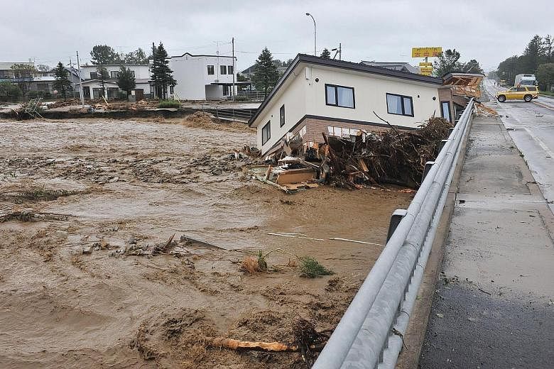 A house being swept down a river in the town of Shimizu in Hokkaido prefecture yesterday after Typhoon Lionrock struck overnight.