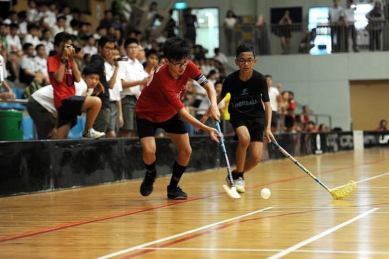 Catholic High School (red) and Northbrooks Secondary School players in action during the Schools National C Division floorball final at Yishun Sports Hall. Both teams were first-time finalists, with CHS winning 3-2.