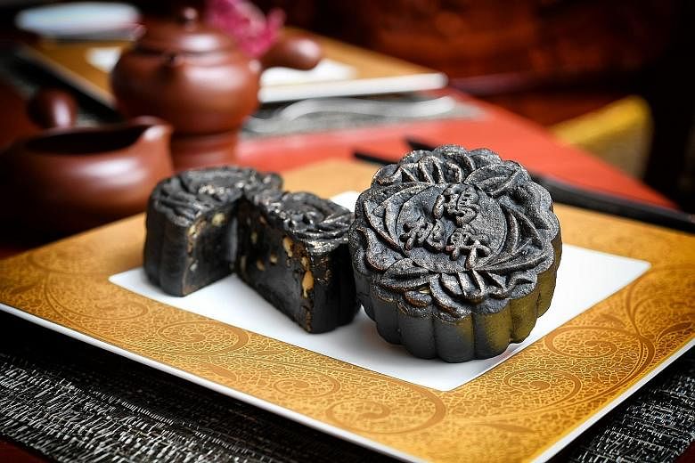 Peach Blossoms' Charcoal Black Sesame Paste with melon seeds and gold dust mooncakes (left).