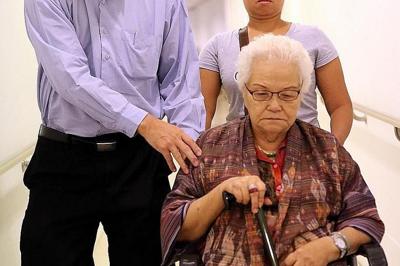 Sheng Siong supermarket boss Lim Hock Chee with his 81-year-old mother, Madam Ng Lye Poh, who testified yesterday, leaving the court with their domestic worker.