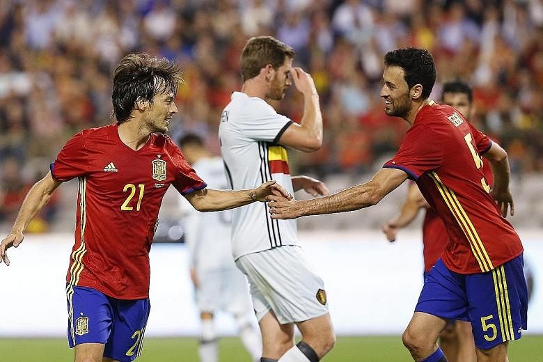 Spain's David Silva (left) celebrating his goal with Sergio Busquets during the friendly match against Belgium on Thursday. Silva scored both goals in the 2-0 win, which will be a boost before their first World Cup qualifier against Liechtenstein.
