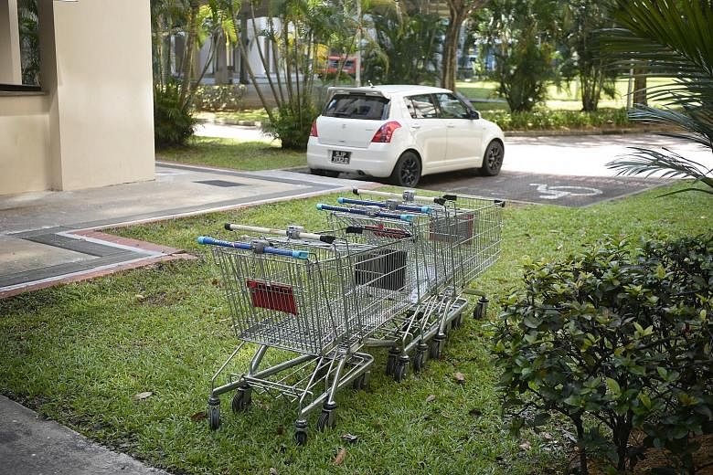 Left: Trolley enforcement officer Kasinathan Sugumaran, 41, helping a FairPrice Xtra customer return her trolley outside Jurong Point. The two FairPrice outlets at the mall have seen 150 to 200 trolleys abandoned daily this year. Above: A bunch of un