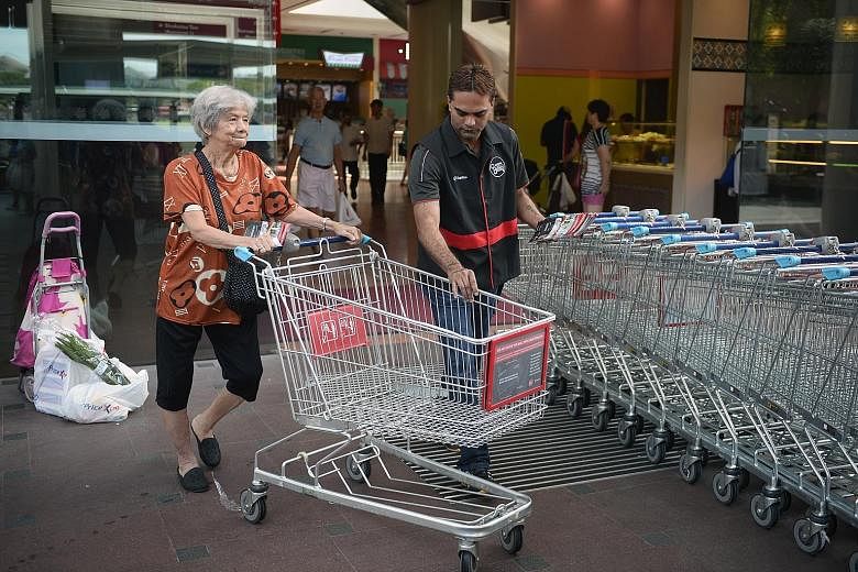 Left: Trolley enforcement officer Kasinathan Sugumaran, 41, helping a FairPrice Xtra customer return her trolley outside Jurong Point. The two FairPrice outlets at the mall have seen 150 to 200 trolleys abandoned daily this year. Above: A bunch of un