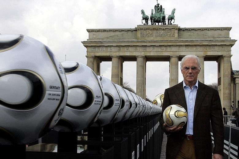 Franz Beckenbauer, the president of Germany's World Cup organising committee, holding a ball next to Brandenburg Gate in 2006. The football legend is now assisting a Swiss investigation into corruption allegations over the awarding of the 2006 World 