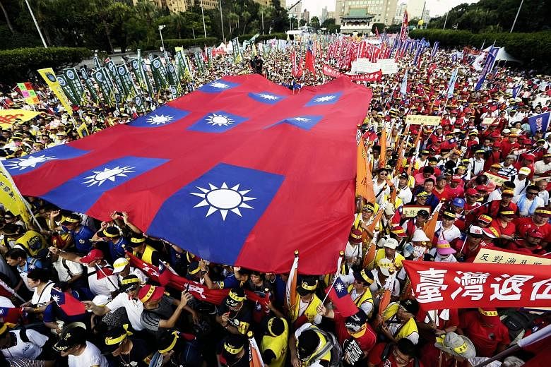 Protesters holding up flags and banners in Taipei yesterday. Organisers estimated the turnout for the three-hour march to be 250,000, but the police put the figure at only 150,000.