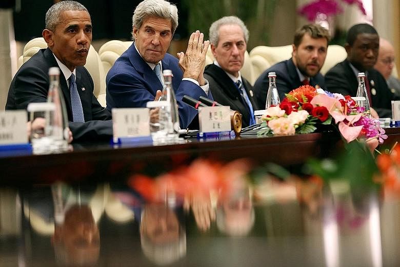 Mr Obama with US Secretary of State John Kerry and other officials at yesterday's meeting. The US President said that despite their differences, both countries hoped their willingness to work together on the climate issue "will inspire further ambiti