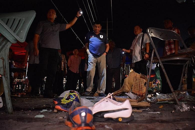 Mr Duterte (centre, in blue shirt) inspecting the site of the explosion at a night market in Davao city, Philippines.