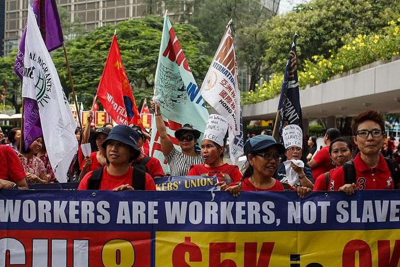 While protesting in Hong Kong yesterday, hundreds of domestic helpers chanted: "We are workers, not slaves." Rally organisers believe at least three maids have died while cleaning windows this year.