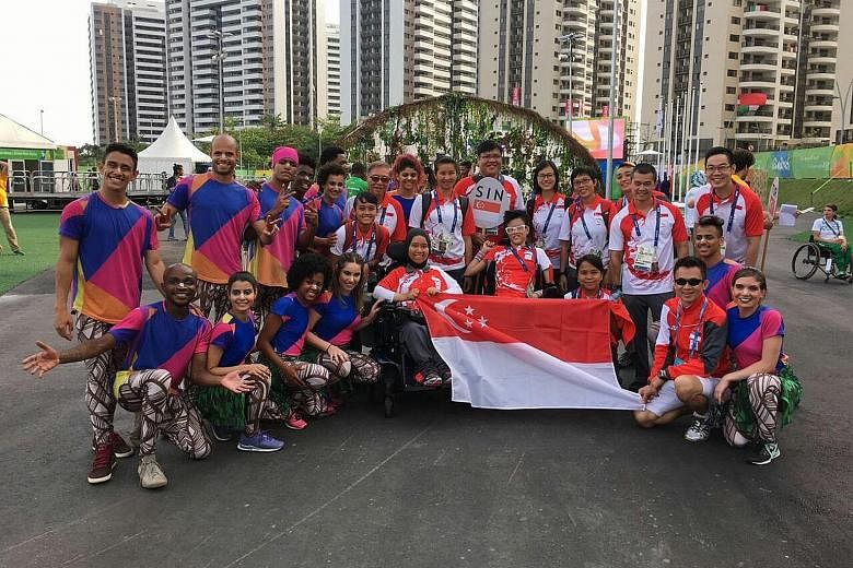 Singapore boccia athletes Nurulasyiqah Taha and Toh Sze Ning (centre, in wheelchairs) and Team Singapore officials posing for photos with Brazilian performers at the Republic's flag-raising ceremony in the Paralympics Athletes Village in Rio de Janei