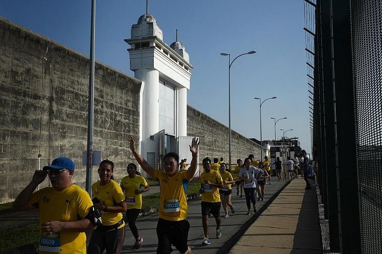 Participants in the 10km category of the Yellow Ribbon Prison Run at the entrance gate and wall of Changi Prison, which was the finishing point of the race. The event raised some $123,000 for the Yellow Ribbon Fund, which helps former inmates.