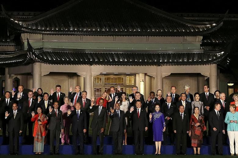 Mr Xi (front row, seventh from left) and his wife Peng Liyuan with US President Barack Obama (front row, fifth from left), Singapore Prime Minister Lee Hsien Loong (second row, fifth from left) and his wife Ho Ching, as well as other leaders and thei