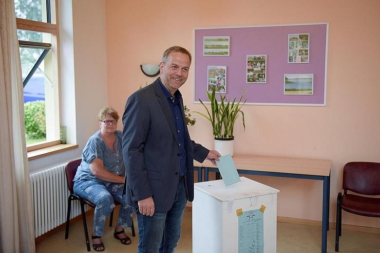 AfD candidate Leif-Erik Holm casting his vote in the Mecklenburg- Western Pomerania state election in Klein Trebbow yesterday. Opinion polls show that Dr Merkel's CDU may be pipped even from second place at the polls.