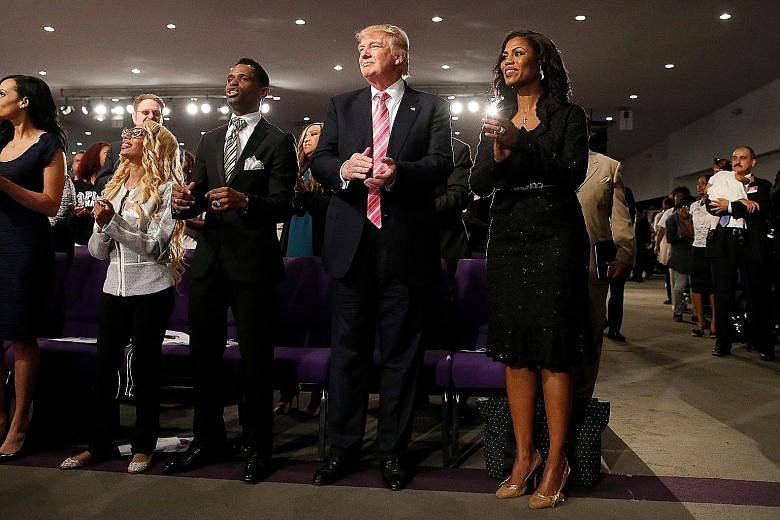 Mr Trump and reality TV personality Omarosa Manigault, director of African-American outreach for his campaign, attending a service at the Great Faith Ministries International Church on Saturday. In his first visit to an African-American church, he to