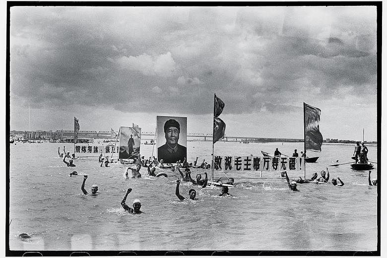 People commemorated the one-year anniversary of chairman Mao Zedong's swim in the Yangtze river by holding his portrait in Songhua River in 1967 (above) - a photograph taken by Li Zhensheng.