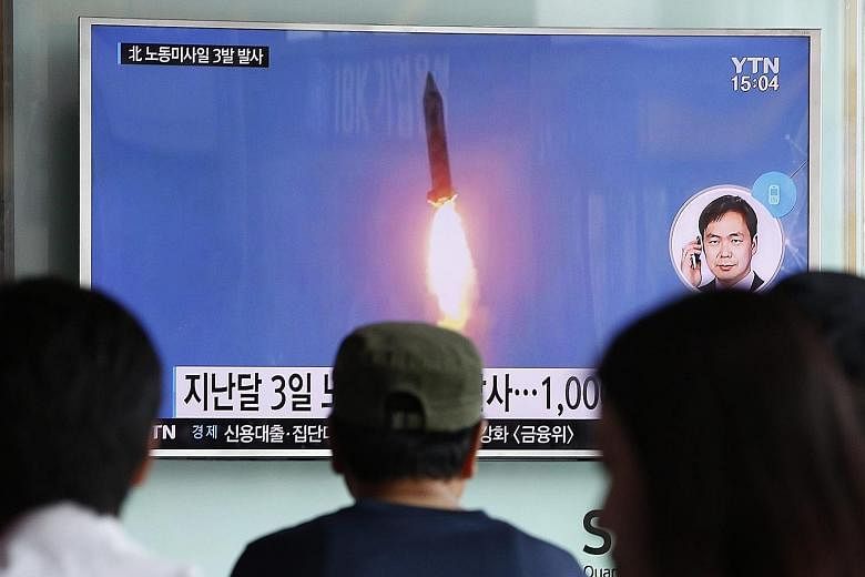 South Koreans watching a report on the launch of three North Korean missiles on TV in Seoul yesterday. The launch was condemned by the US as "reckless".
