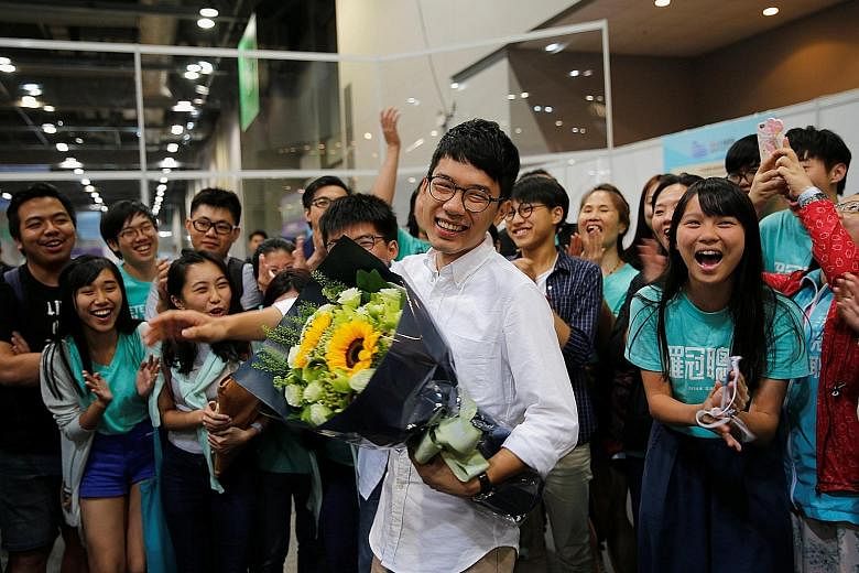 Mr Nathan Law, the election's youngest candidate at 23, celebrating yesterday with supporters after he won a seat in the Legislative Council. Sunday's polls were the first major election after 2014's Occupy protests, which many young localist candida