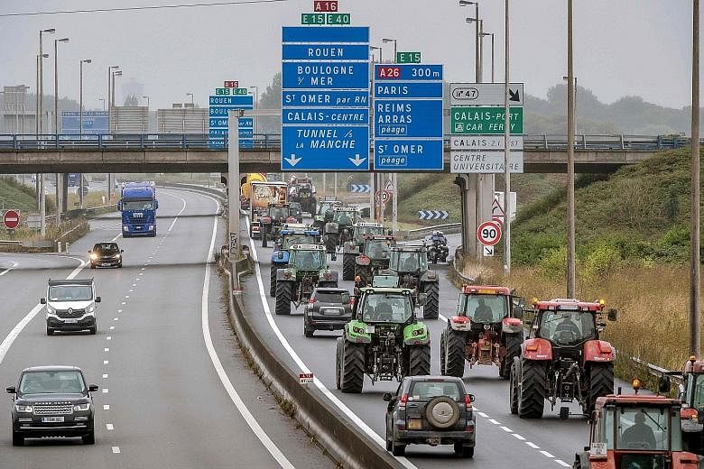 Truck drivers and farmers driving from Loon Plage to Calais on the A16 highway yesterday during a joint "go-slow" protest calling for the dismantling of the so-called "Jungle" migrant camp in Calais.