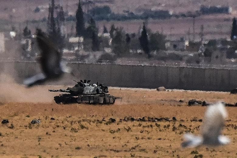 A Turkish tank advancing from Syria during clashes between the Turkish army and ISIS militants on Sunday.