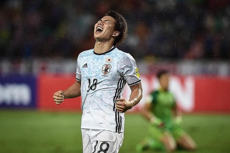 Japan forward Takuma Asano celebrates after scoring against Thailand in a World Cup qualifier yesterday. Japan won 2-0.