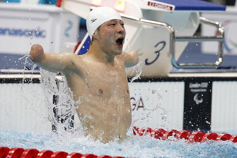 China's Xu Qing celebrates winning the 50m fly S6 final at London 2012. He won four golds in the British capital and has similar targets in Rio. The tattoo on his back (below) shows that he means business.