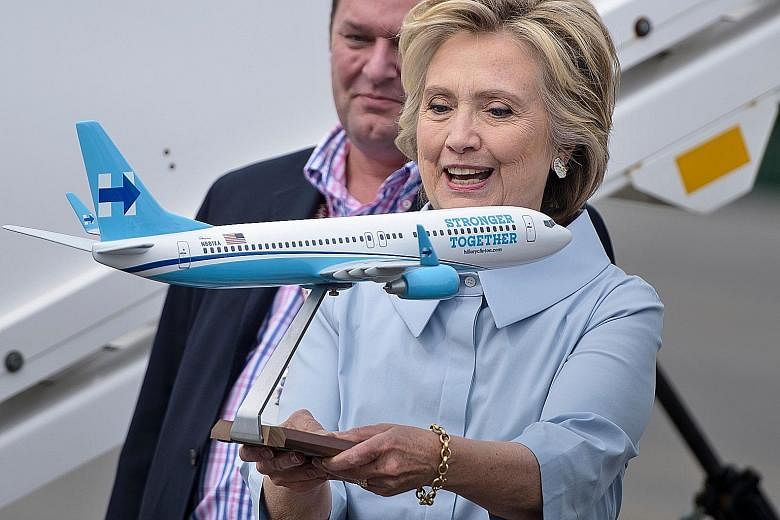 Mrs Clinton with a model of her new campaign plane at Westchester County Airport before travelling to Ohio on Monday. Her new jet is a Boeing 737-800 that seats about 100 people. It has "Stronger Together" emblazoned along the fuselage and her tradem