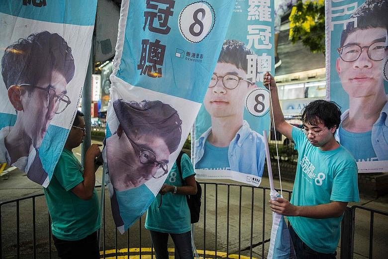 Chief Executive Leung said he thinks the election results "have nothing to do with the chances of anyone who aspires to be the next Chief Executive of Hong Kong". Supporters of Mr Nathan Law putting up flags in Causeway Bay following Mr Law's win in 