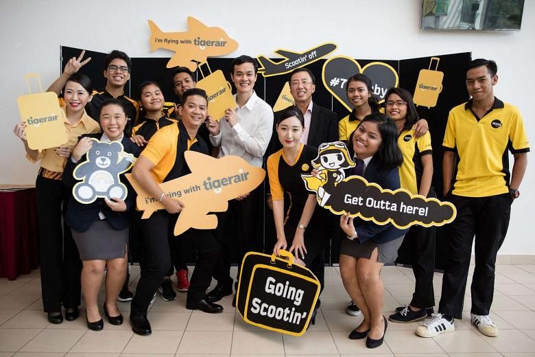 Mr Lee Lik Hsin, CEO of Budget Aviation Holdings (in white shirt) and Mr Bruce Poh, CEO of ITE (in black jacket), with ITE students and Scoot and Tigerair staff. Cabin crew interns joining next year will earn full-time pay. 