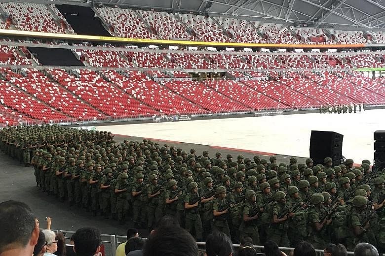 Recruits from the Basic Military Training Centre and the 3rd Battalion of the Singapore Guards at the stadium during their passing-out parade yesterday, watched by family members and friends.
