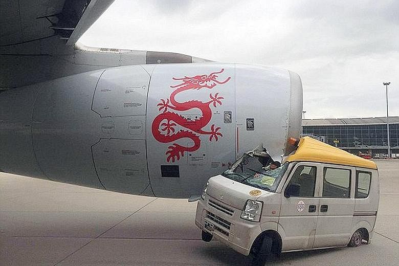 A delivery van wedged under the engine of a Dragonair plane after a collision at Hong Kong International Airport yesterday. Video footage showed the van heading towards the Airbus A-330 as it rolled towards the runway for take-off. The vehicle then s