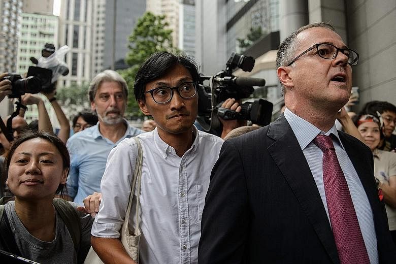 Social activist-turned-lawmaker Eddie Chu (centre) and lawyer Michael Vidler arriving at Wan Chai Police headquarters yesterday. Mr Chu said he had received "credible death threats" against him and his family.