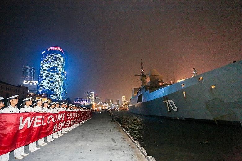RSS Steadfast being welcomed by Chinese naval officers in Shanghai yesterday. This is the warship's second port call in Shanghai, the first being in 2008. Singapore's Col Cheong (at right) being welcomed yesterday by PLA Navy's Captain Lu Xing, the d