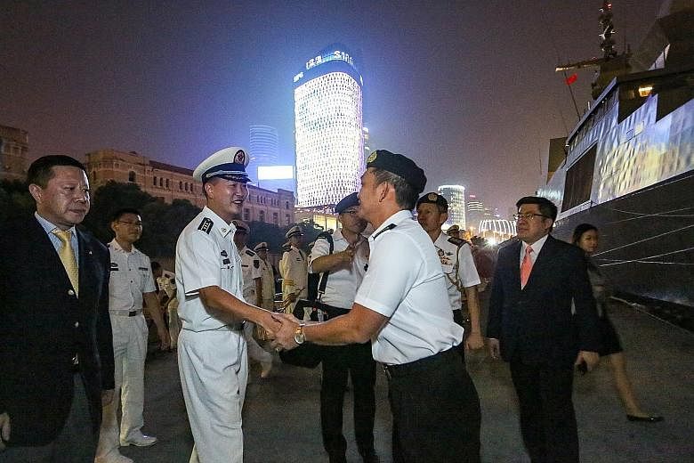 RSS Steadfast being welcomed by Chinese naval officers in Shanghai yesterday. This is the warship's second port call in Shanghai, the first being in 2008. Singapore's Col Cheong (at right) being welcomed yesterday by PLA Navy's Captain Lu Xing, the d