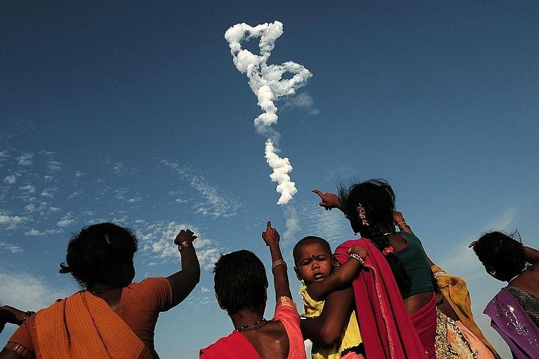 Bystanders looking on as the Indian Space Research Organisation's (Isro) satellite INSAT-3DR, on board Geosynchronous Satellite Launch Vehicle GSLV-F05, launched from Sriharikota, an island off the Bay of Bengal coast in the state of Andhra Pradesh, 