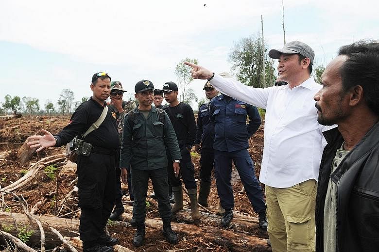 Above: A canal allegedly being built on peatland in the concession licensed to Rapp. Such canals could result in peatland becoming dry and vulnerable to fires. Below: BRG chief Nazir Foead (in white shirt) had attempted to conduct a surprise inspecti