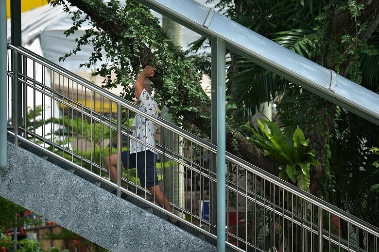 A man doing stretching exercises while walking up an overhead bridge in Toa Payoh Lorong 6 yesterday. With the number of seniors rising even as family support gets weaker, the demand for institutions providing elderly care will grow. However, with se