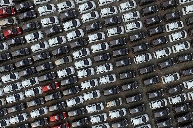 Electric cars seen at a carpark of a factory in China's Hebei province. Both domestic and foreign carmakers have been accused of breaking rules on subsidies for electric and hybrid vehicles. The scandal is a setback to China's goal of achieving full-