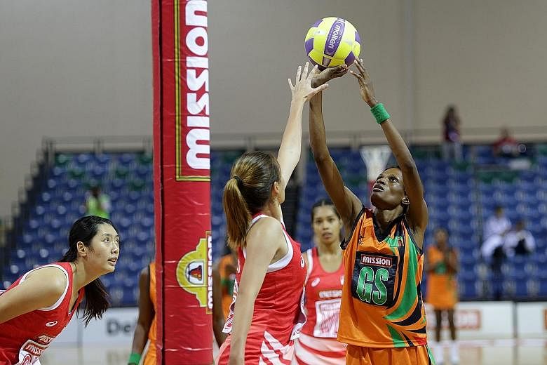 Zambia's Hellen Banda (right) preparing to shoot as Singapore goal defender Shina Teo attempts to block her shot. Zambia won 50-45 and will face Papua New Guinea in the final today.