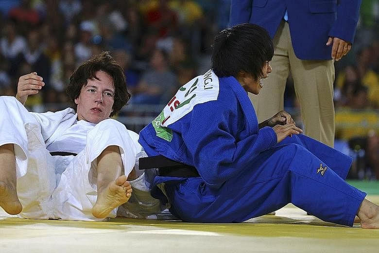 China's Li Liqing (right) is overcome by emotion during the women's judo 48kg final against Germany's defending champion Carmen Brussig.