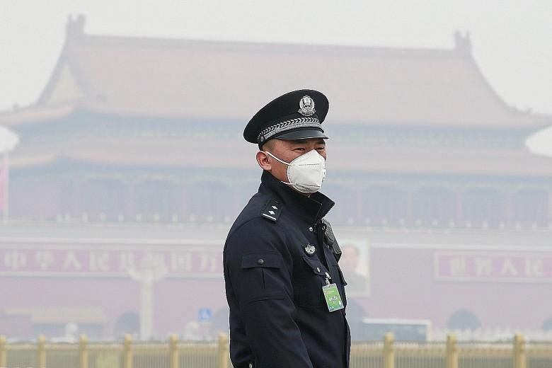 A policeman in Beijing wearing a mask for protection against air pollution in March. The aggregate cost of premature deaths was more than US$5 trillion (S$6.7 trillion) worldwide in 2013.