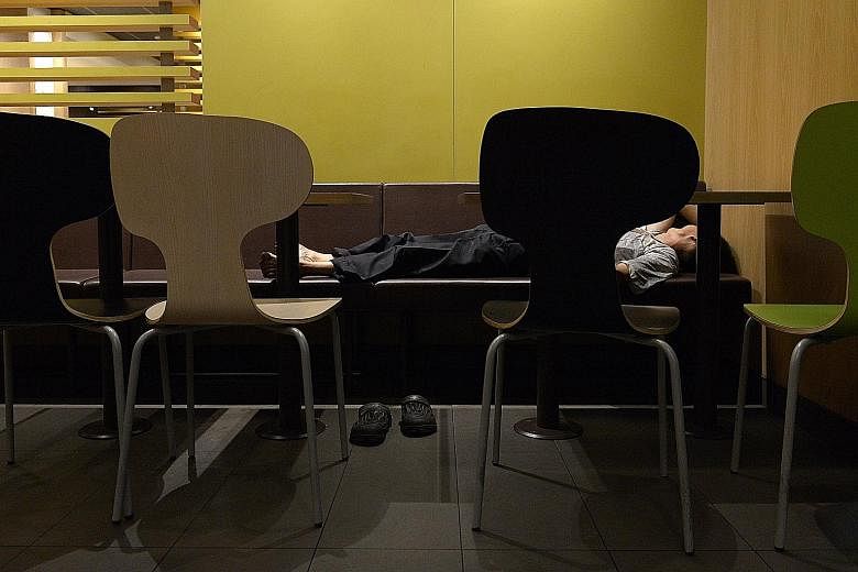 Patrons at a McDonald's outlet in the southern part of Singapore early yesterday morning. Some seek respite in the air- conditioned outlets while others find it hard to sleep at home.