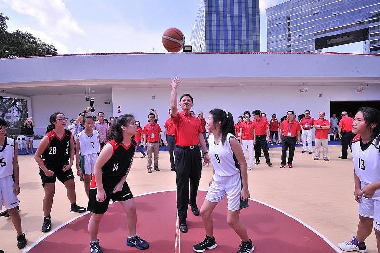 Mr Chan starting a five-a-side game at the basketball court of the upgraded Cairnhill CC yesterday. The court, which was on the ground floor before, is now on the third floor.