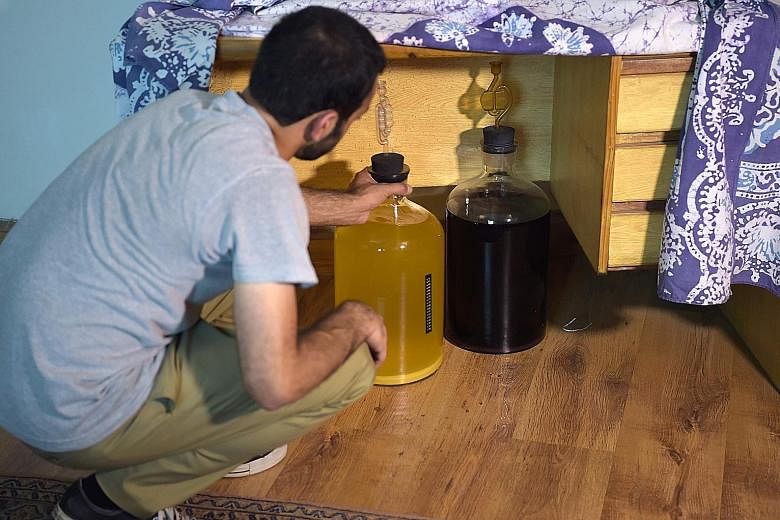 A Pakistani resident keeping bottles of homemade whisky out of sight, under a table at his home in Islamabad.