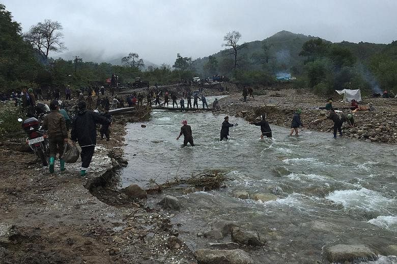 Villagers working together to repair roads connecting the counties in the North Korean province of North Hamyong which were affected by the floods, in a photo released yesterday. At least 133 people have died in the floods in the country's north.