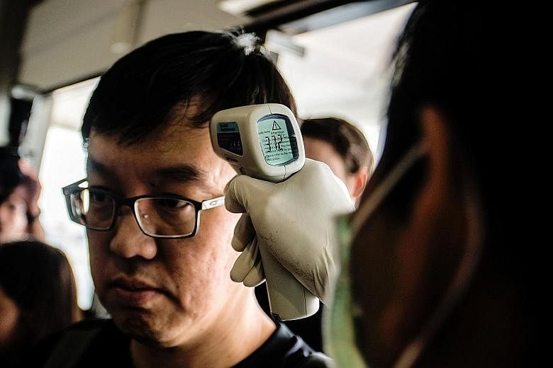 A health official at Yogyakarta airport checking the temperature of a passenger arriving from Singapore on Sept 2, after Zika cases were reported in the Republic.