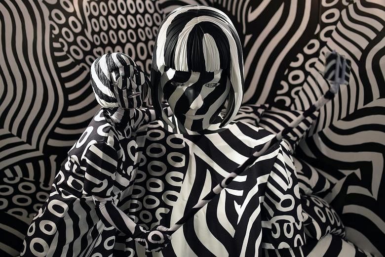 A woman (left) blending right in with Japanese painter Shigeki Matsuyama's art installation, Narcissism: Dazzle Room, during the Rooms 33 fashion and design trade show at Yoyogi National Stadium in Tokyo yesterday. Since 2000, Rooms has been a biannu